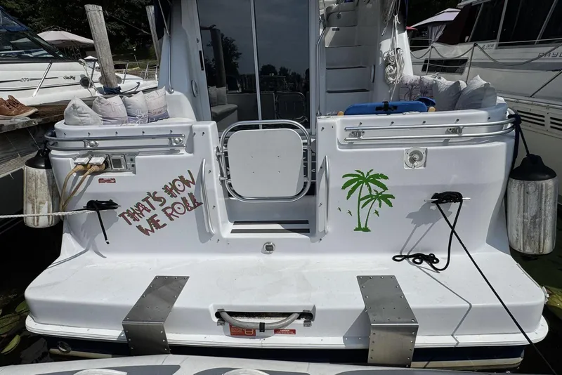 Slide: The Image of 1998 Mainship 31 Sedan Bridge boat with palm tree and "That's How We Roll" text. - 5