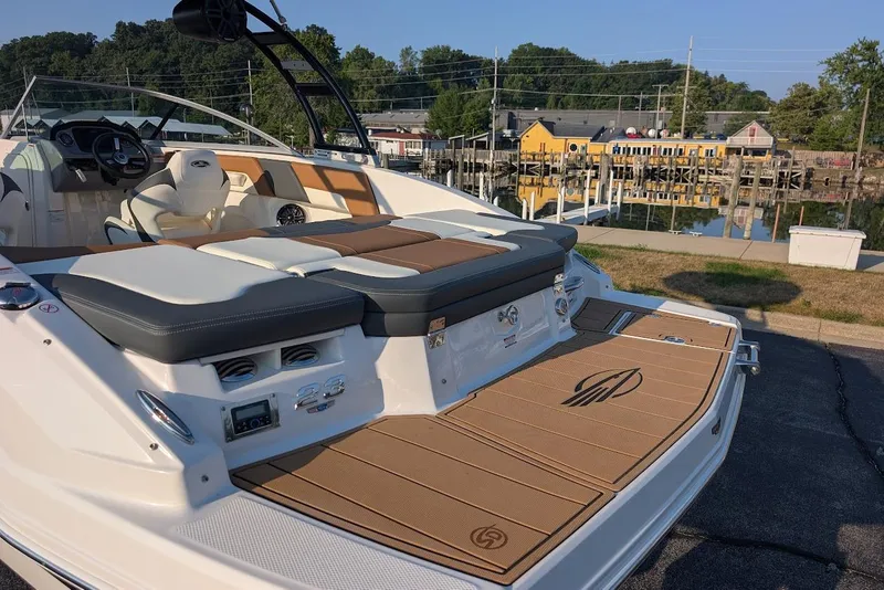 Slide: The Image of 2023 Chaparral 23 SSi boat with luxurious seating and sleek design docked by the waterfront. - 9