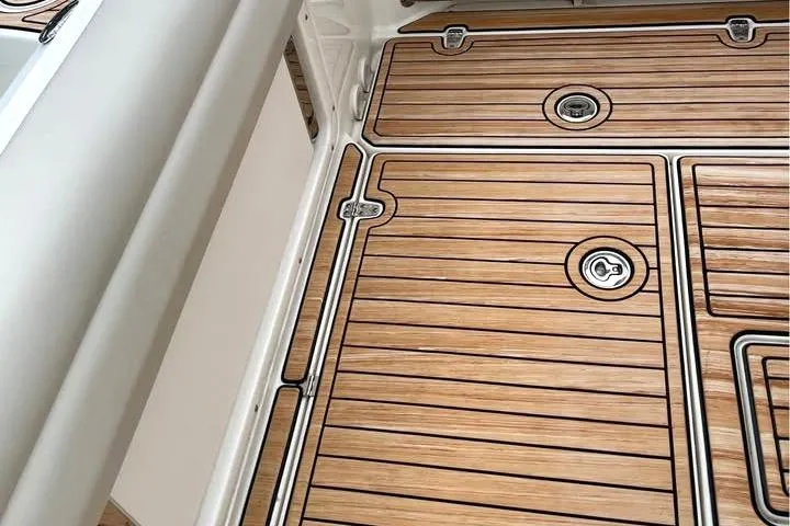 Slide: The Image of 2021 Boston Whaler 250 Outrage deck with sleek wood finish and secure hatches. - 10