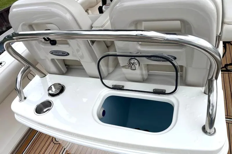 Slide: The Image of 2021 Boston Whaler 250 Outrage boat interior with open storage compartment and stainless steel railing. - 7