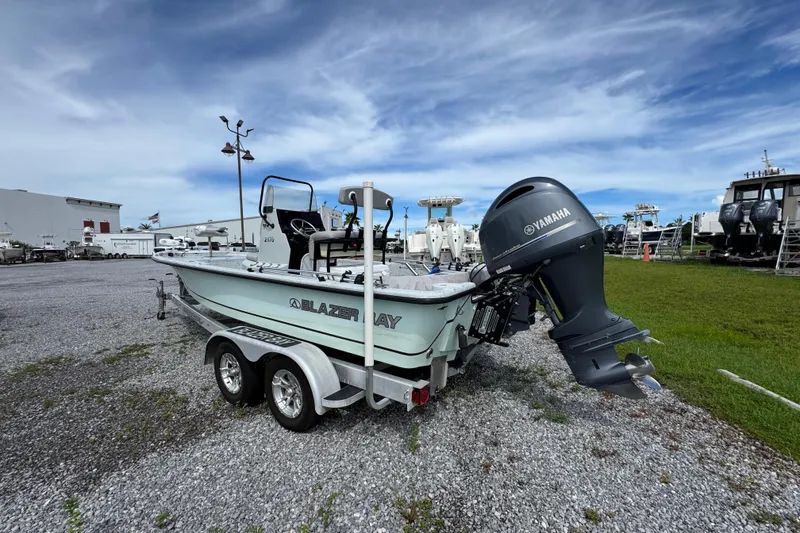 Slide: The Image of 2018 Blazer Bay 2170 boat with Yamaha motor on a trailer, parked outdoors. - 10