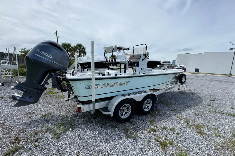 Slide: The Image of 2018 Blazer Bay 2170 boat with Yamaha motor on a trailer in a gravel lot. - 13