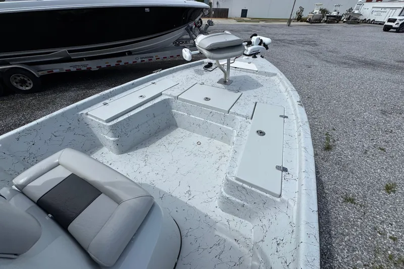 Slide: The Image of 2018 Blazer Bay 2170 boat with seating and storage compartments, parked on gravel. - 14