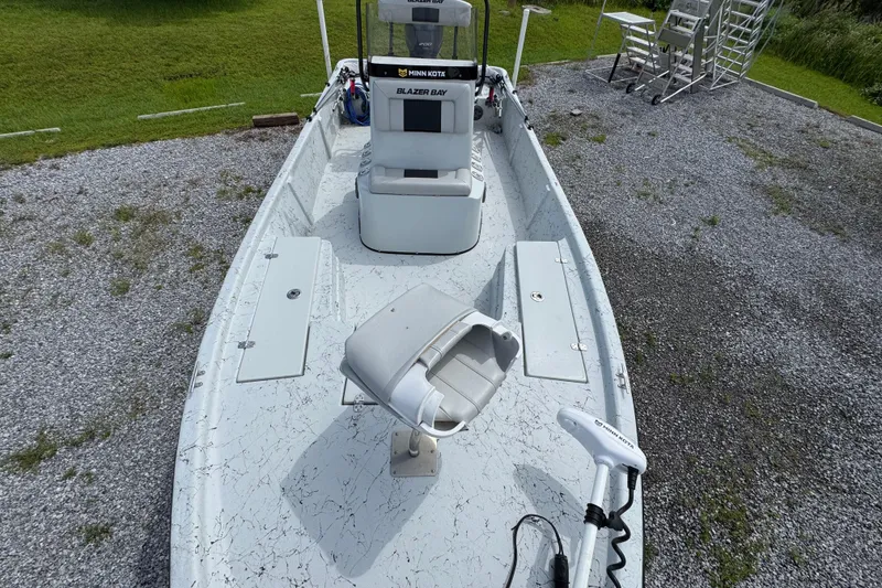 Slide: The Image of 2018 Blazer Bay 2170 boat on gravel, featuring seating and storage compartments. - 18