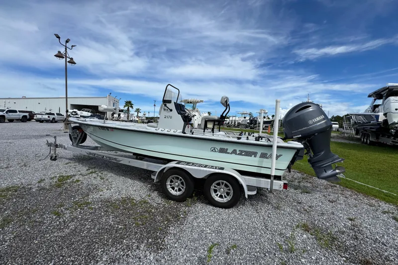 Slide: The Image of 2018 Blazer Bay 2170 boat on trailer, parked outdoors under a cloudy sky. - 9