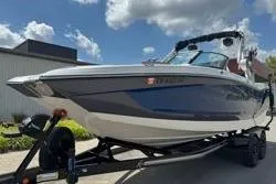 Slide: The Image of 2021 MasterCraft X24 boat on trailer, parked outdoors under a clear blue sky. - 4