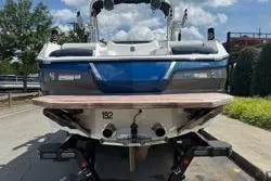 Slide: The Image of 2021 MasterCraft X24 boat on trailer under a blue sky with clouds. - 6