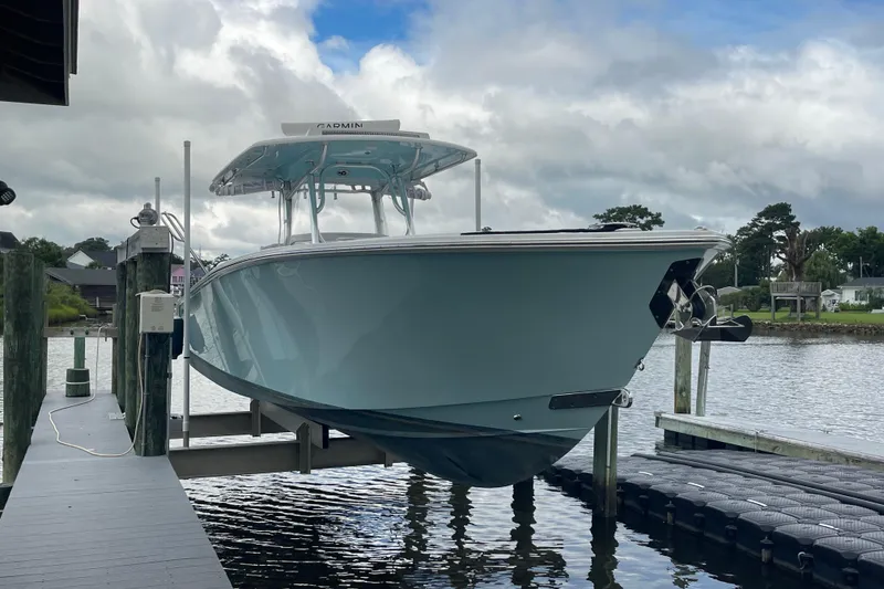 Slide: The Image of 2020 Jupiter 38 boat docked on a lift, under cloudy skies. - 11