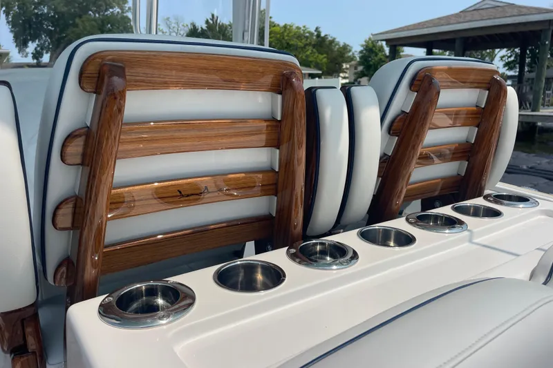 Slide: The Image of Luxury seating on a 2020 Jupiter 38 boat with wooden accents and cup holders. - 44
