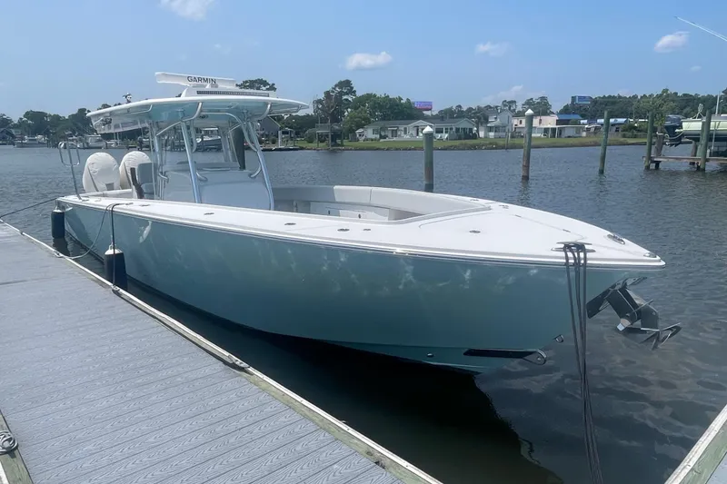 Slide: The Image of 2020 Jupiter 38 boat docked on a calm river under a clear blue sky. - 5