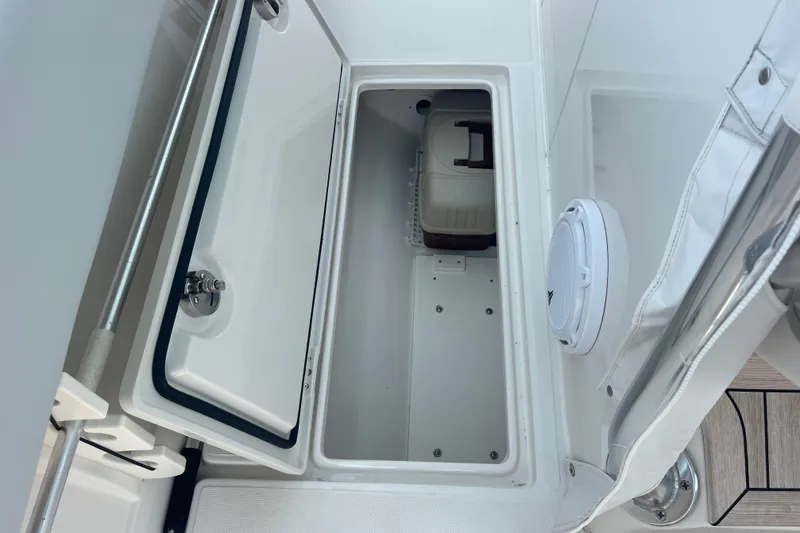 Slide: The Image of Open storage compartment on a 2020 Jupiter 38 boat, featuring a white interior and secure latch. - 56