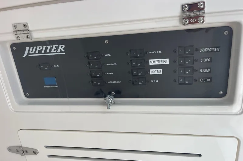 Slide: The Image of Control panel of a 2020 Jupiter 38 boat with labeled switches and battery indicator. - 58