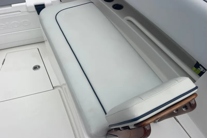 Slide: The Image of 2020 Jupiter 38 boat interior with white cushioned seating and storage compartment. - 75