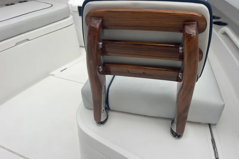 Slide: The Image of Wooden seat backrest on a 2020 Jupiter 38 boat, featuring sleek white upholstery. - 76