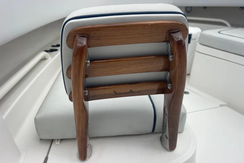 Slide: The Image of Wooden seat back on a 2020 Jupiter 38 boat, featuring white and blue upholstery. - 77