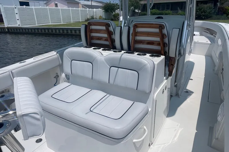Slide: The Image of 2020 Jupiter 38 boat interior with white cushioned seating and cup holders. - 8