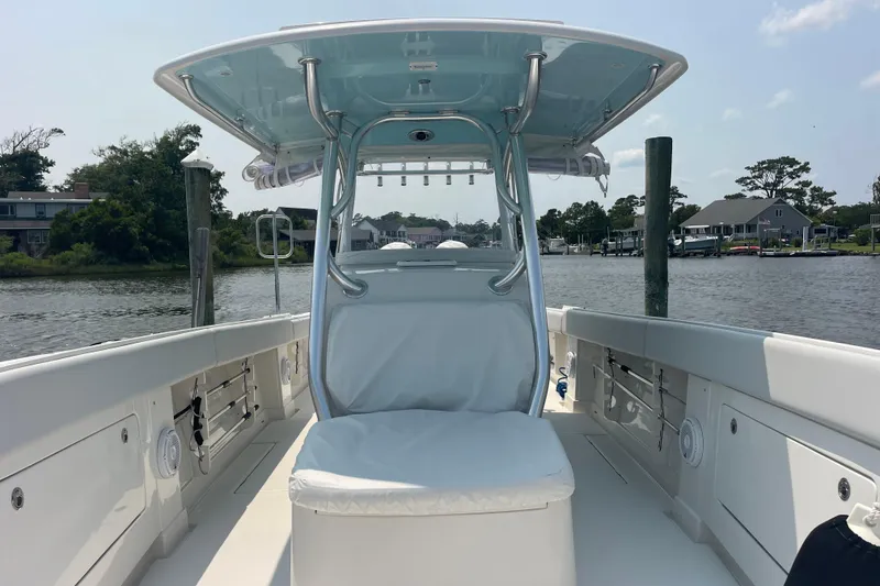 Slide: The Image of 2020 Jupiter 38 boat interior with seating, docked by a scenic waterfront. - 80