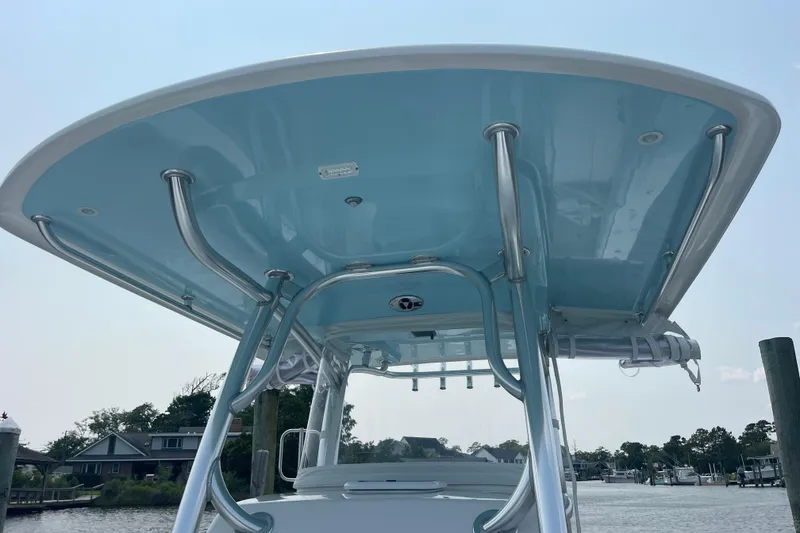 Slide: The Image of 2020 Jupiter 38 boat with blue T-top and stainless steel supports at a marina. - 84