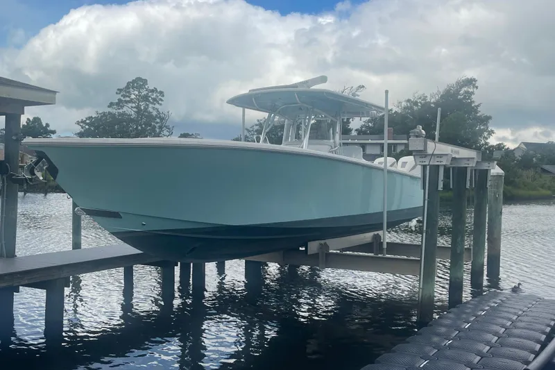 Slide: The Image of 2020 Jupiter 38 boat on lift by waterfront, under cloudy sky. - 9