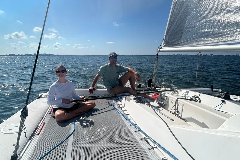 Slide: The Image of Two people sailing on a 2006 Corsair Sprint 750 trimaran under clear skies. - 10
