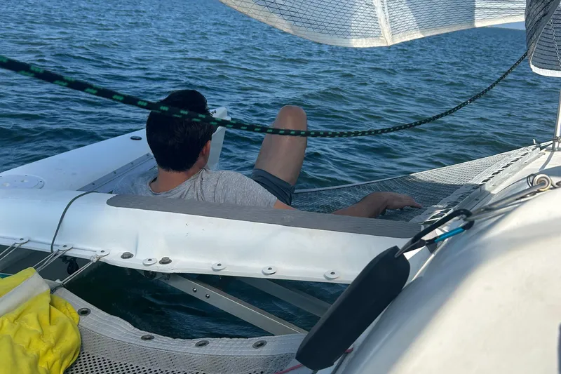 Slide: The Image of Person relaxing on a 2006 Corsair Sprint 750 sailboat, enjoying the water. - 15
