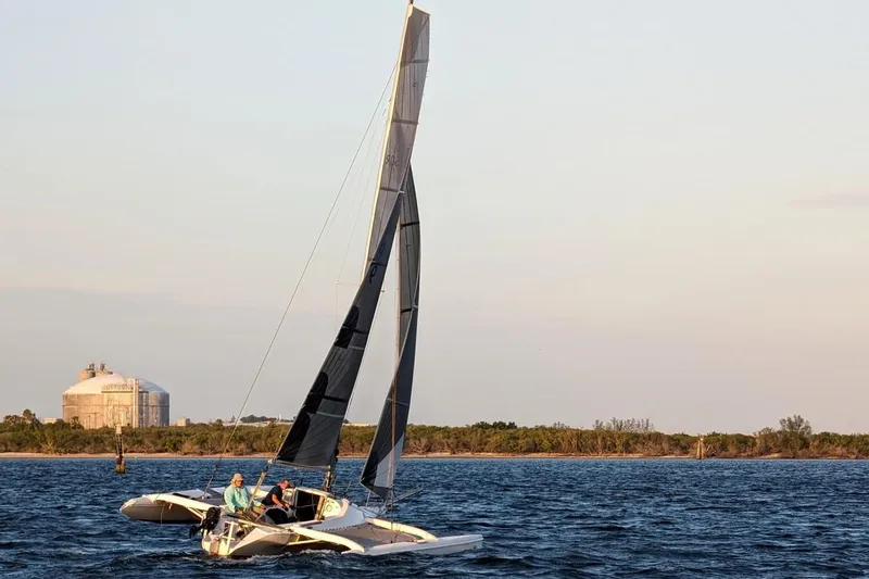 Slide: The Image of 2006 Corsair Sprint 750 sailing on open water at sunset. - 18