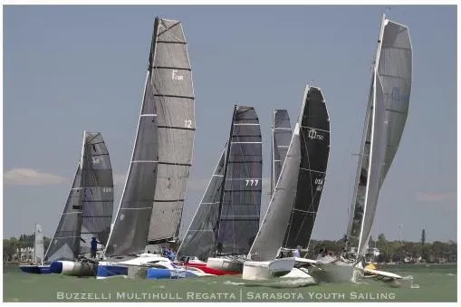 Slide: The Image of Sailboats racing in Buzzelli Multihull Regatta, featuring a 2006 Corsair Sprint 750. - 2