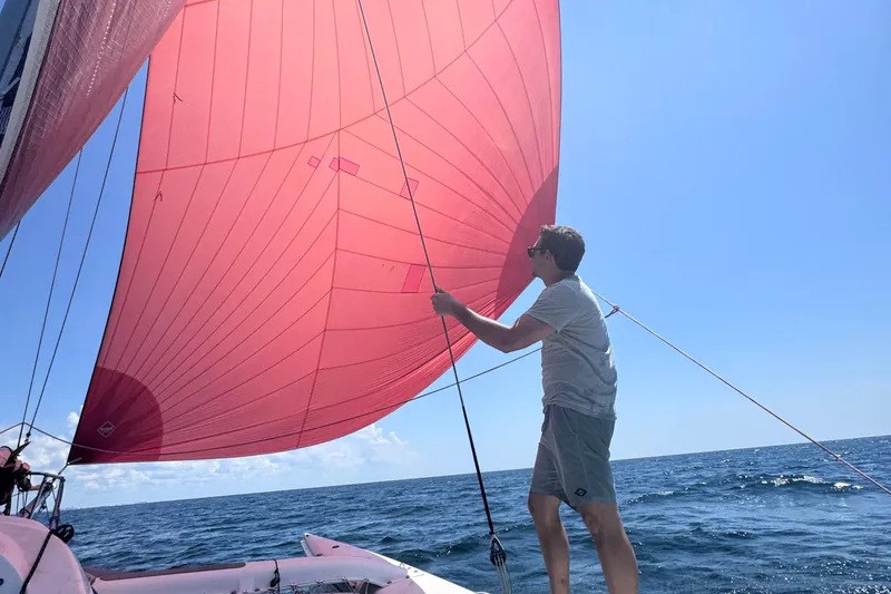 Slide: The Image of Man sailing Corsair Sprint 750, 2006 model, with red sail on open sea. - 8