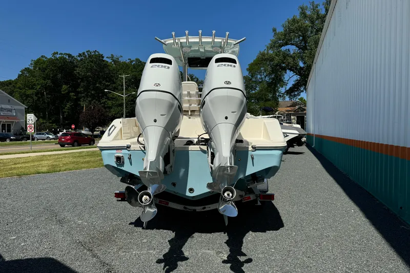 Slide: The Image of 2024 Bulls Bay 255 boat with dual outboard engines, parked outdoors. - 4