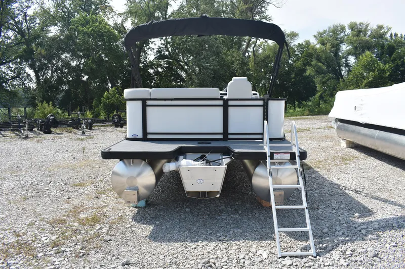 Slide: The Image of 2026 Godfrey SWEETWATER SW 2086 C pontoon boat with ladder, parked on gravel. - 2