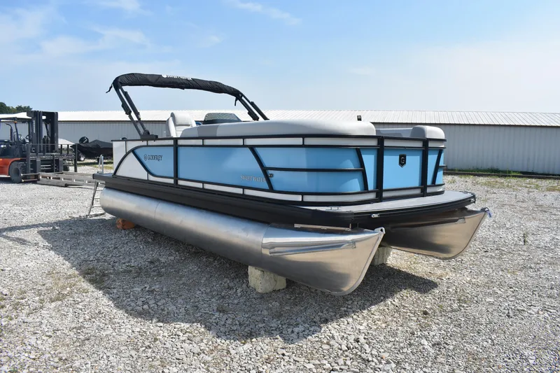 Slide: The Image of 2026 Godfrey SWEETWATER SW 2086 C pontoon boat on gravel lot, blue and silver design. - 4