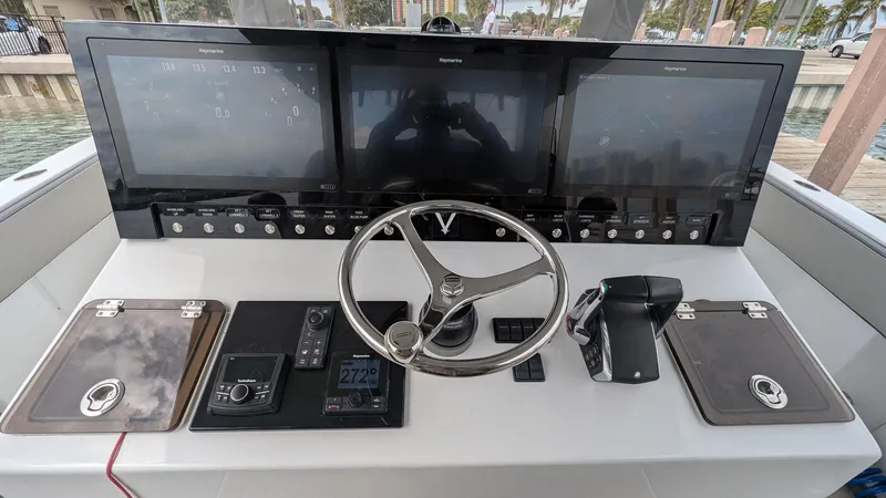 Slide: The Image of Control panel of 2021 Vela 368 Center Console boat with steering wheel and navigation screens. - 20