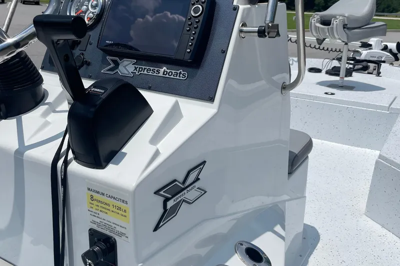 Slide: The Image of 2023 Express H22 boat console with controls and seating, featuring Xpress Boats branding. - 10