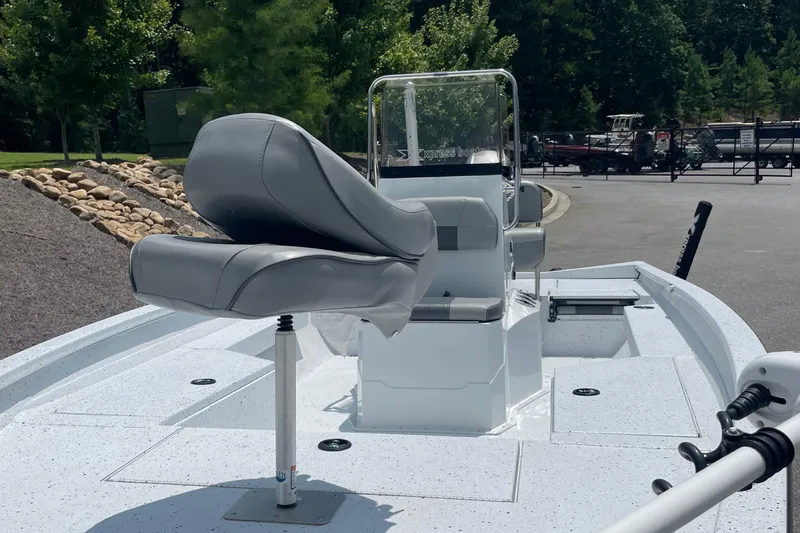 Slide: The Image of 2023 Express H22 boat with gray seating and console, parked outdoors. - 12