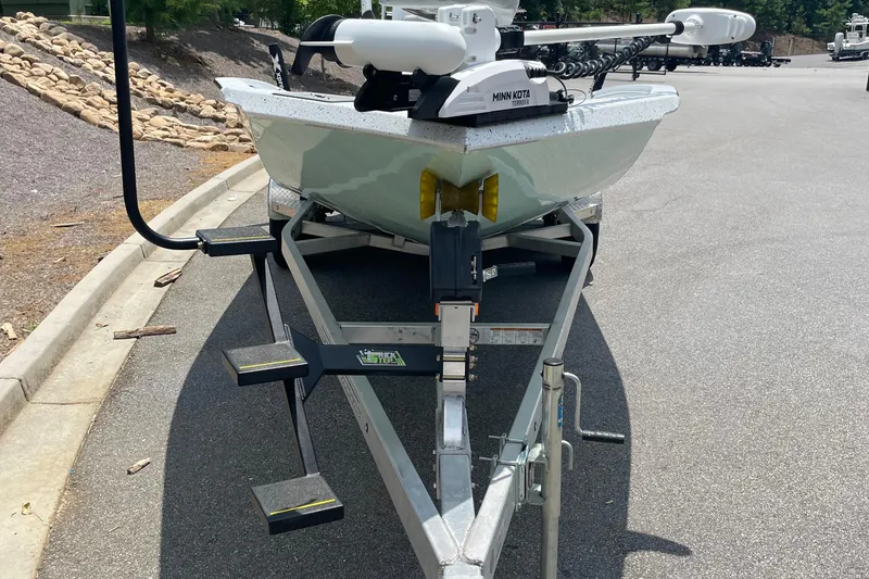 Slide: The Image of 2023 Express H22 boat on trailer with Minn Kota motor, parked on asphalt. - 13