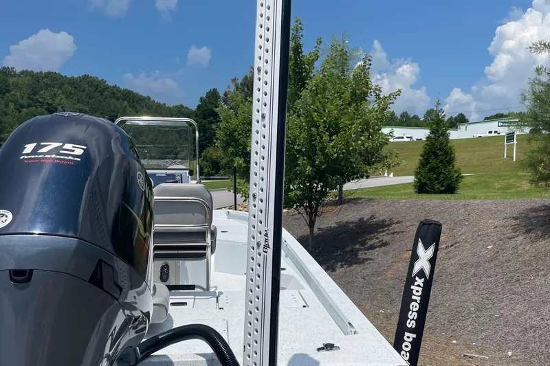 Slide: The Image of 2023 Express H22 boat with 175 horsepower engine, parked outdoors on a sunny day. - 6