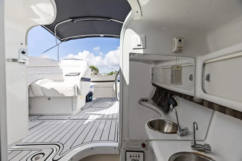 Slide: The Image of 2007 Formula 280 Bowrider interior with seating, sink, and canopy under blue sky. - 10