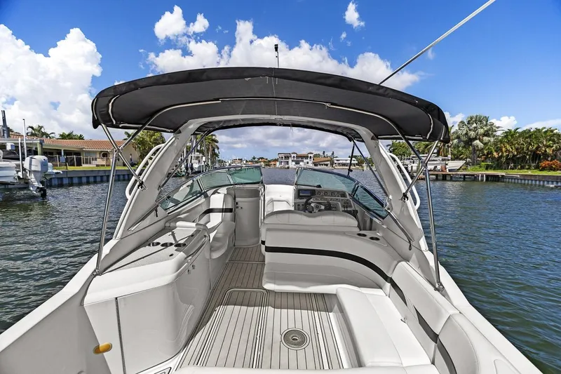Slide: The Image of 2007 Formula 280 Bowrider boat with canopy, docked in a scenic waterfront location. - 30
