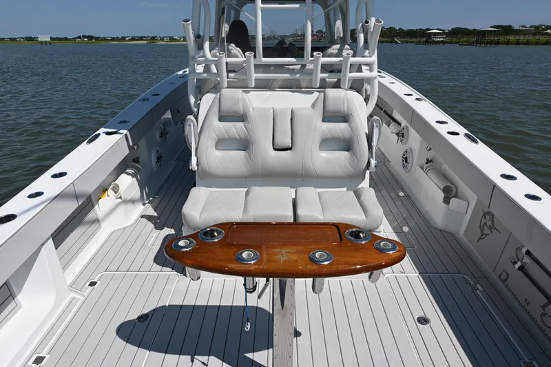 Slide: The Image of 2021 Freeman 37VH boat interior with white seating and wooden table on water. - 16