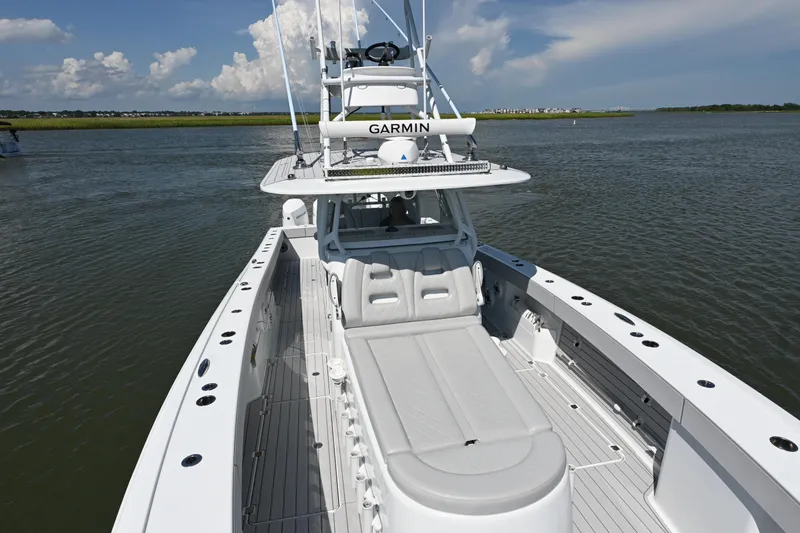 Slide: The Image of 2021 Freeman 37VH boat on calm water, featuring spacious deck and Garmin equipment. - 25