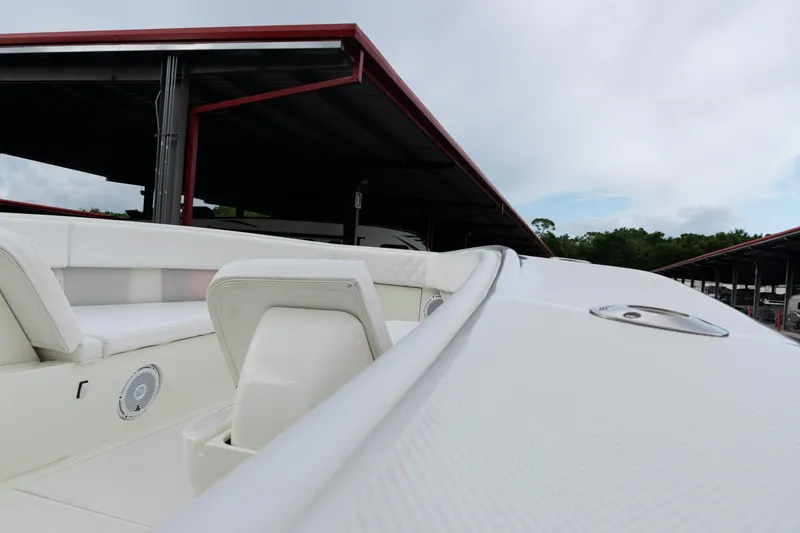 Slide: The Image of 2017 SeaVee 340Z boat interior with white seating and speaker, docked under shelter. - 12