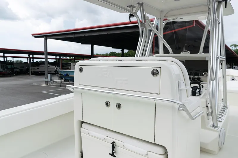 Slide: The Image of 2017 SeaVee 340Z boat interior with console and storage, parked under a covered area. - 20