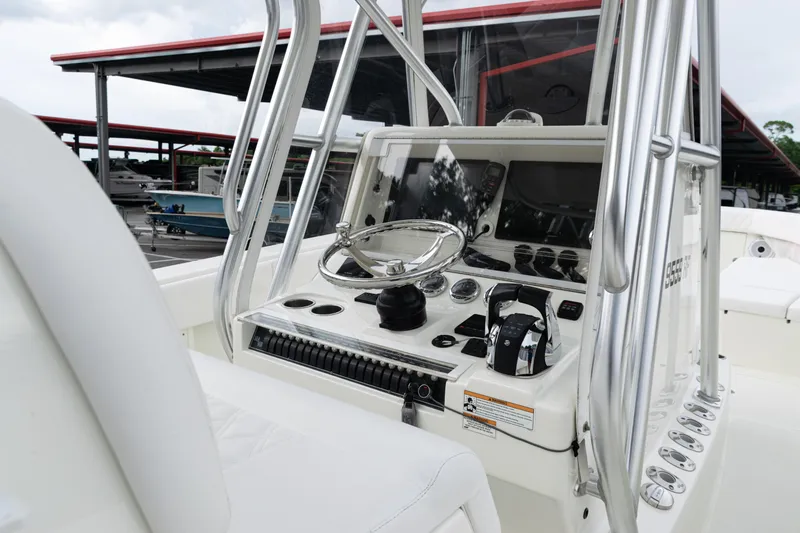 Slide: The Image of 2017 SeaVee 340Z boat console with steering wheel and controls, docked under a covered marina. - 23