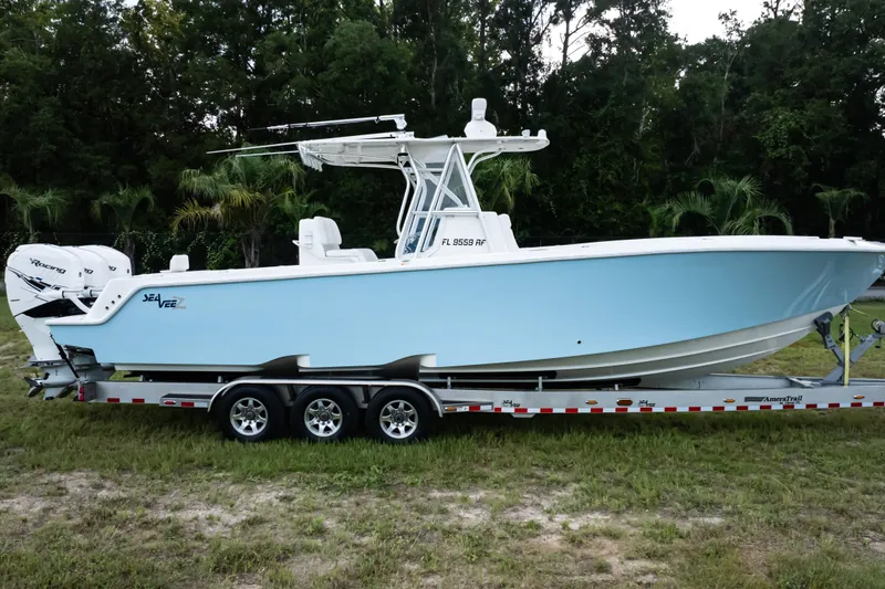 Slide: The Image of 2017 SeaVee 340Z boat with triple outboard engines on a trailer in a grassy area. - 3