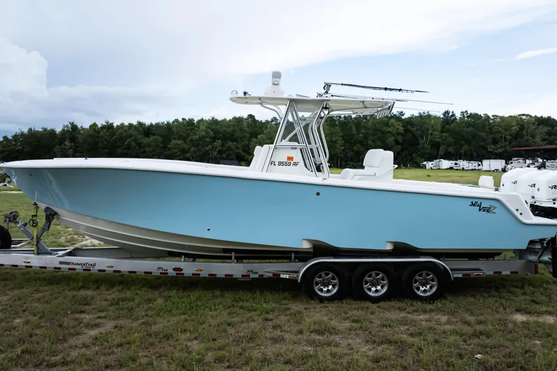 Slide: The Image of 2017 SeaVee 340Z boat on trailer, light blue hull, parked on grass. - 4
