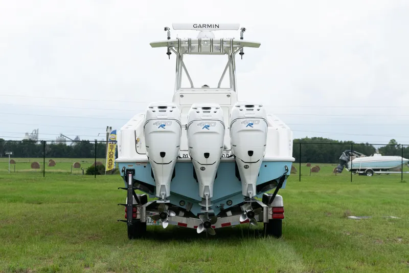 Slide: The Image of 2017 SeaVee 340Z boat with triple outboard engines on a grassy field. - 48