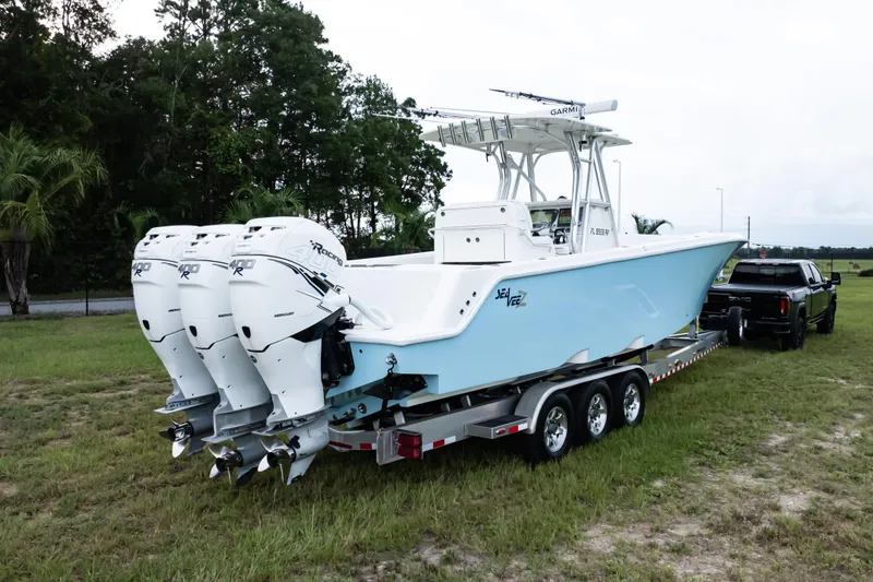 Slide: The Image of 2017 SeaVee 340Z boat on trailer with triple outboard engines, parked on grass. - 52