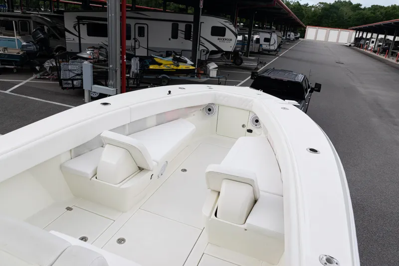 Slide: The Image of 2017 SeaVee 340Z boat interior with white seating, parked near RVs and trailers. - 6
