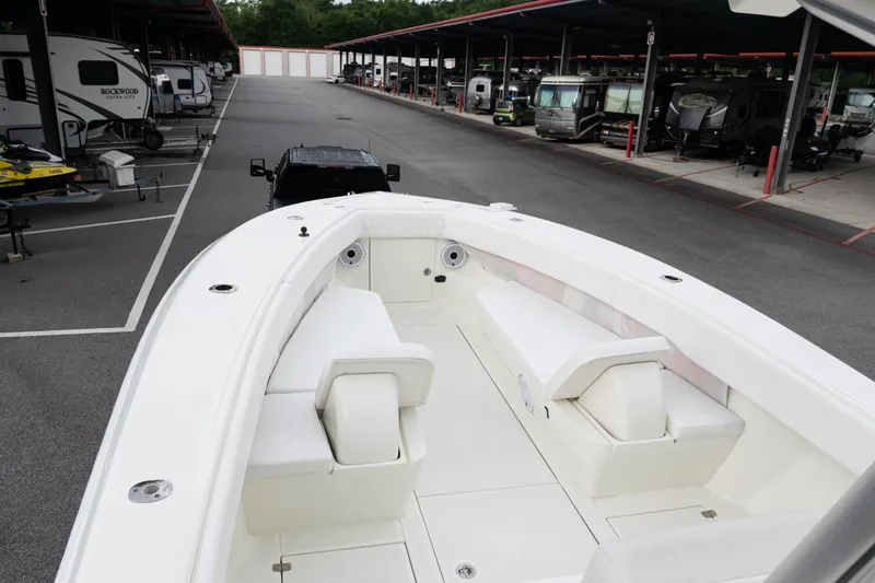 Slide: The Image of 2017 SeaVee 340Z boat with white seating, parked in a covered storage area. - 8