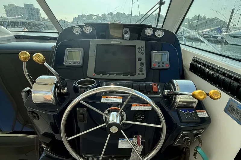 Slide: The Image of 2008 Tiara Yachts 3000 Open helm with steering wheel and navigation controls. - 13